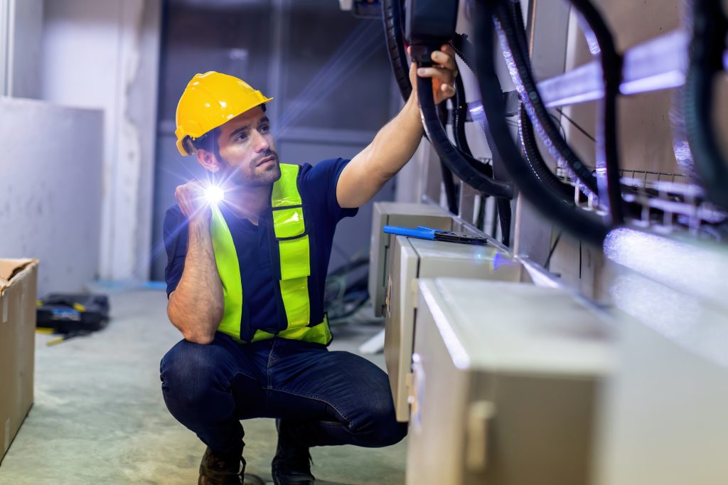 Electrical engineer man checking Power Distribution Cabinet in the control room